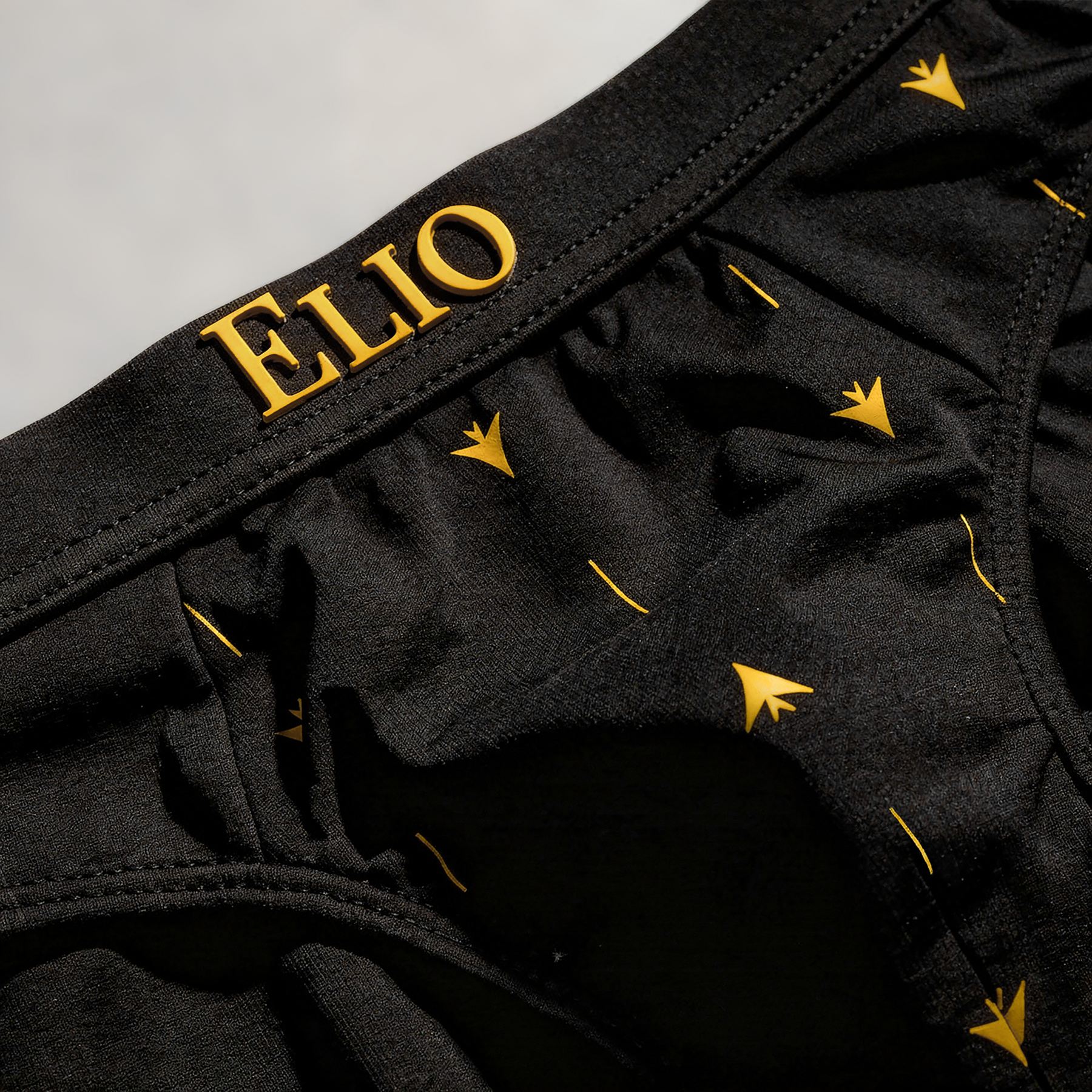 ELIO Black brief waistband detail, gold arrow motif print, ELIO logo branding